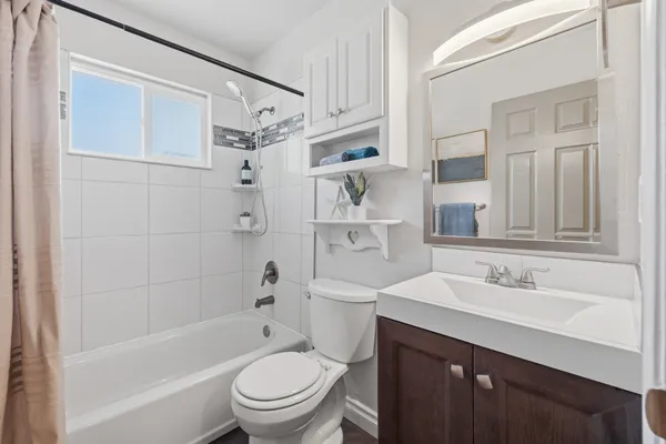 a bathroom with a sink toilet vanity and shower