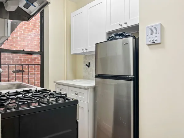a kitchen with stainless steel appliances and refrigerator