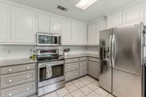 a kitchen with stainless steel appliances granite countertop a refrigerator stove and cabinets