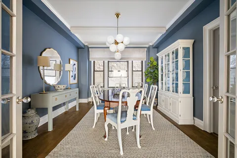 a view of a dining room with furniture a chandelier and wooden floor