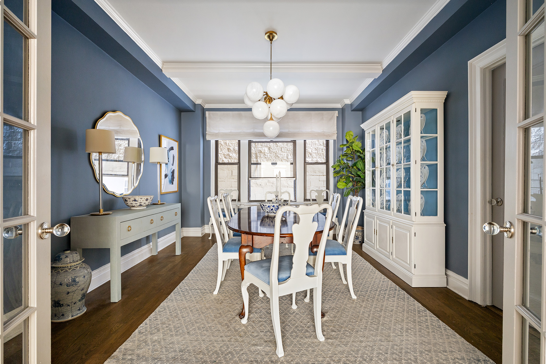 129 East 82nd Street, Unit 1C Manhattan, NY 10028 - Photo 4 of 13 a view of a dining room with furniture a chandelier and wooden floor