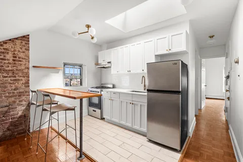 a kitchen with kitchen island a counter top space a sink appliances and cabinets