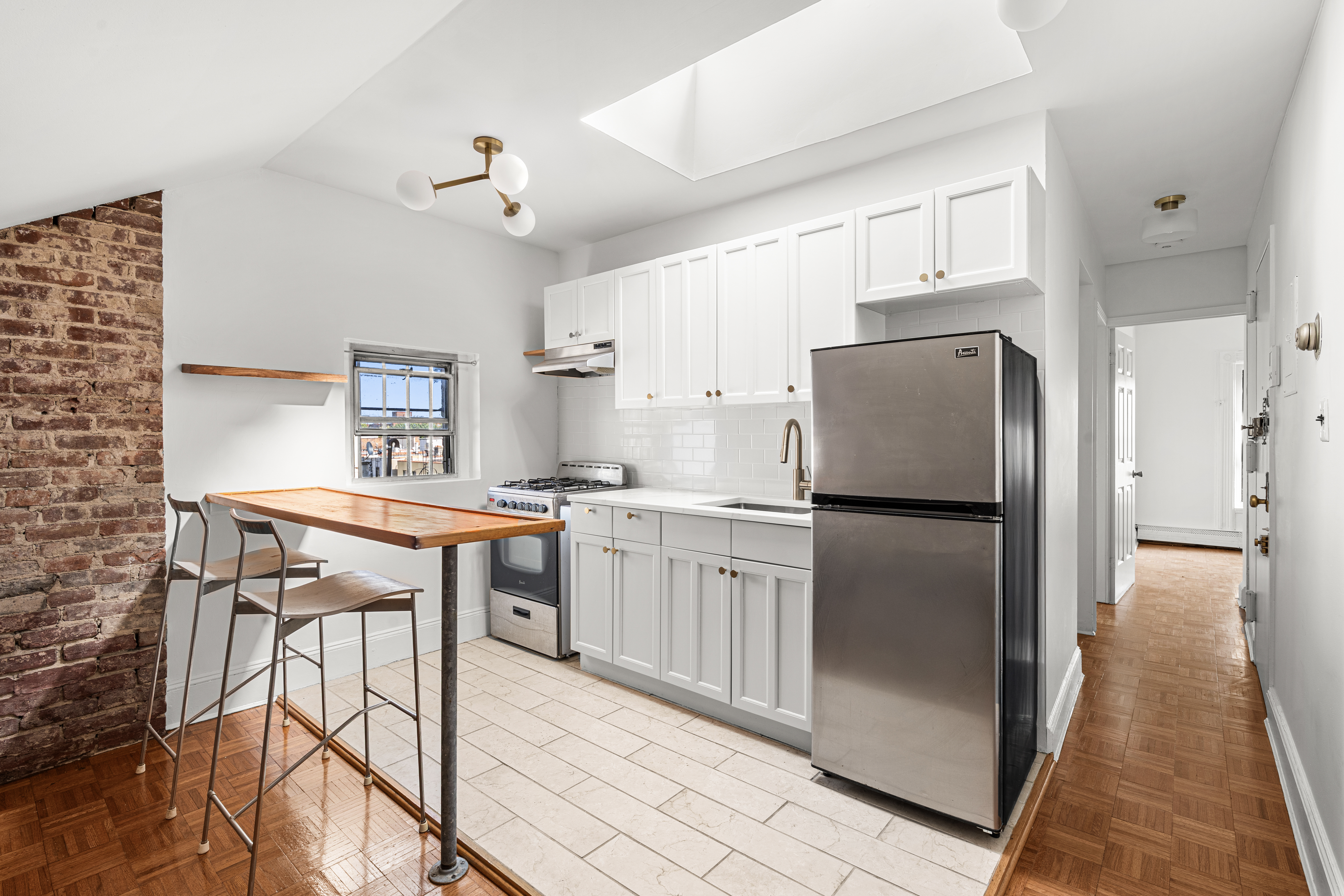 306 Lafayette Avenue, Unit 4 Brooklyn, NY 11238 - Photo 3 of 11 a kitchen with kitchen island a counter top space a sink appliances and cabinets