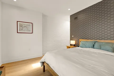 a bedroom with a bed and a wall painting