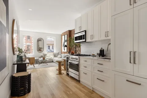 a large white kitchen with stainless steel appliances