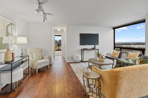 a living room with furniture a flat screen tv and a large window