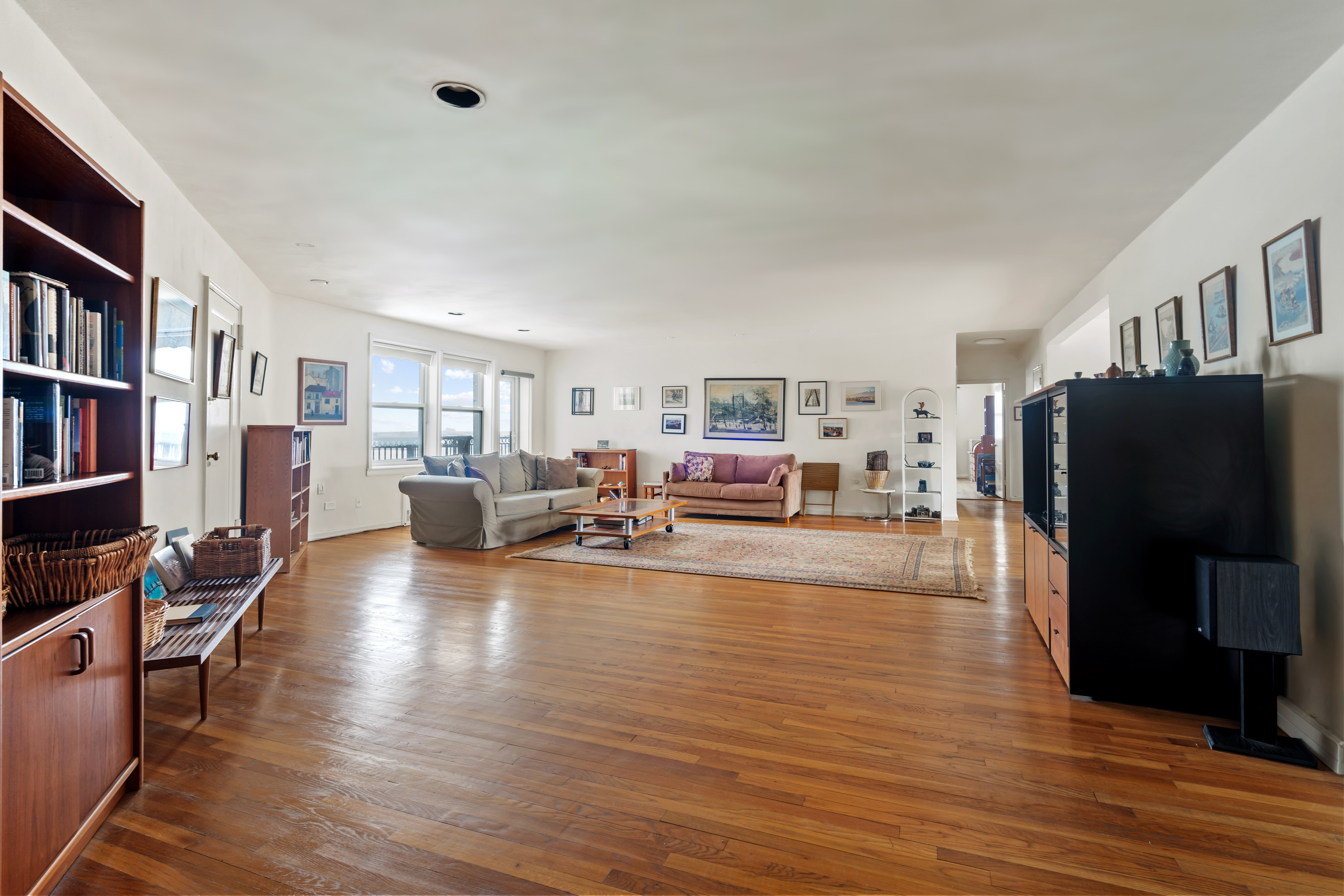 162-01 Powells Cove Boulevard, Unit 4R Queens, NY 11357 - Photo 2 of 12 a living room with furniture and a flat screen tv
