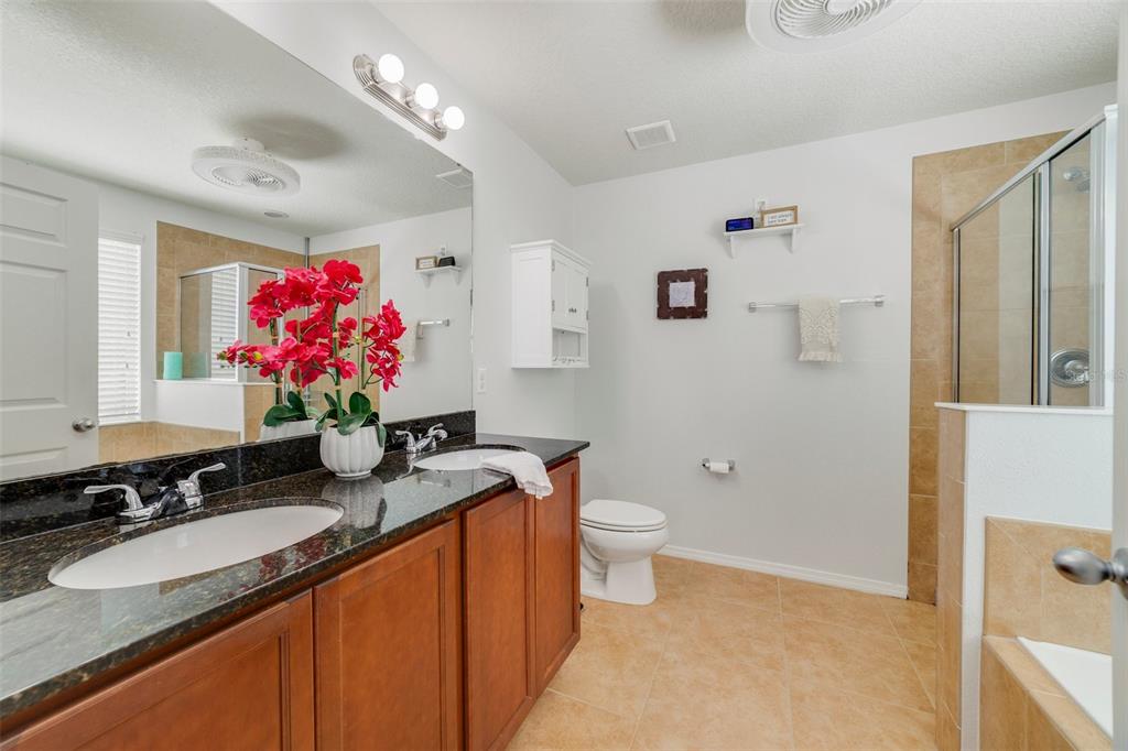 352 Giovani Boulevard Clermont, FL 34715 - Photo 25 of 46 a bathroom with a granite countertop sink mirror vanity and toilet