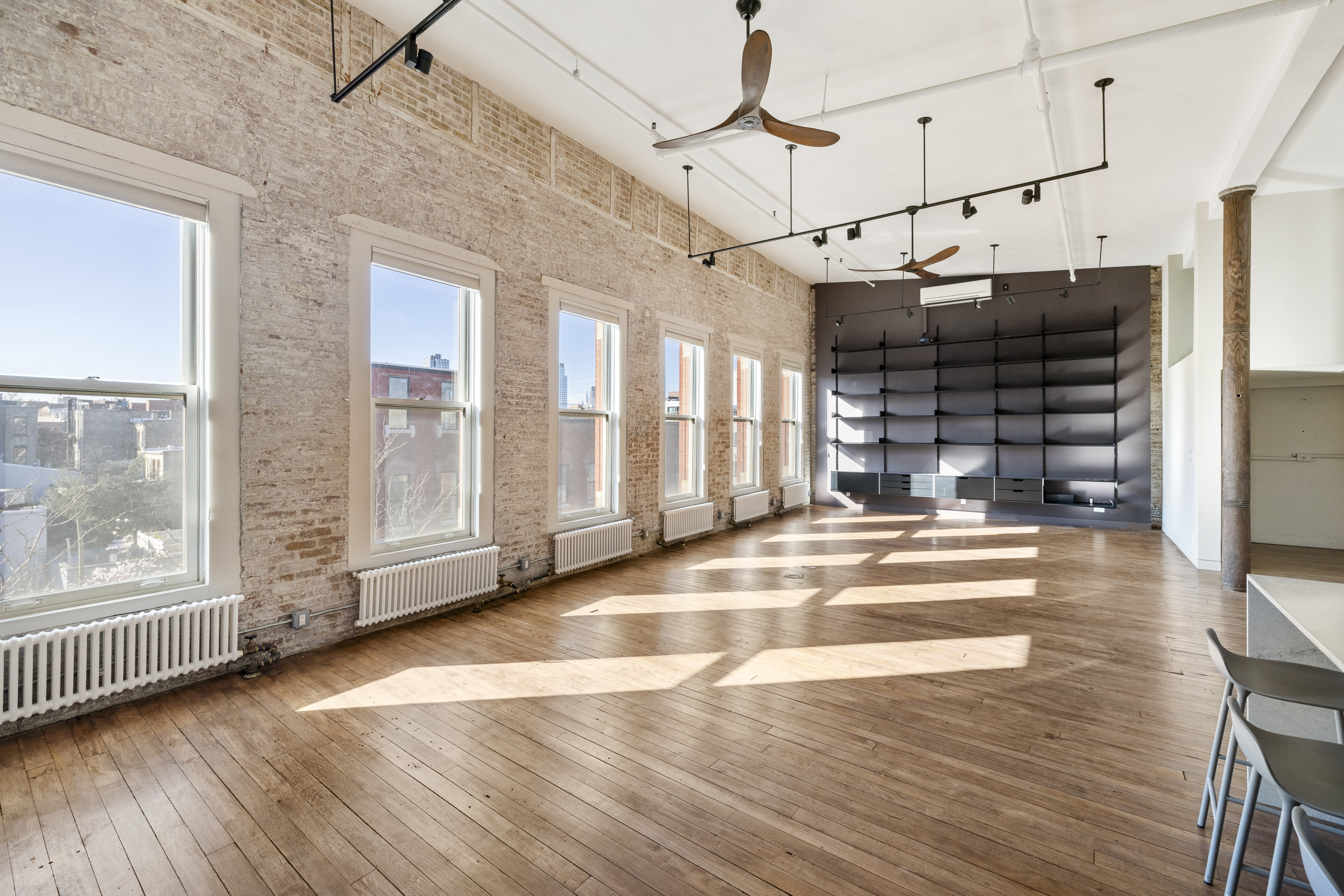 705 Driggs Avenue, Unit 13 Brooklyn, NY 11211 - Photo 2 of 15 a view of empty room with wooden floor and windows