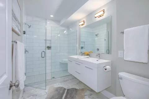 a view of bathroom with shower sink and mirror