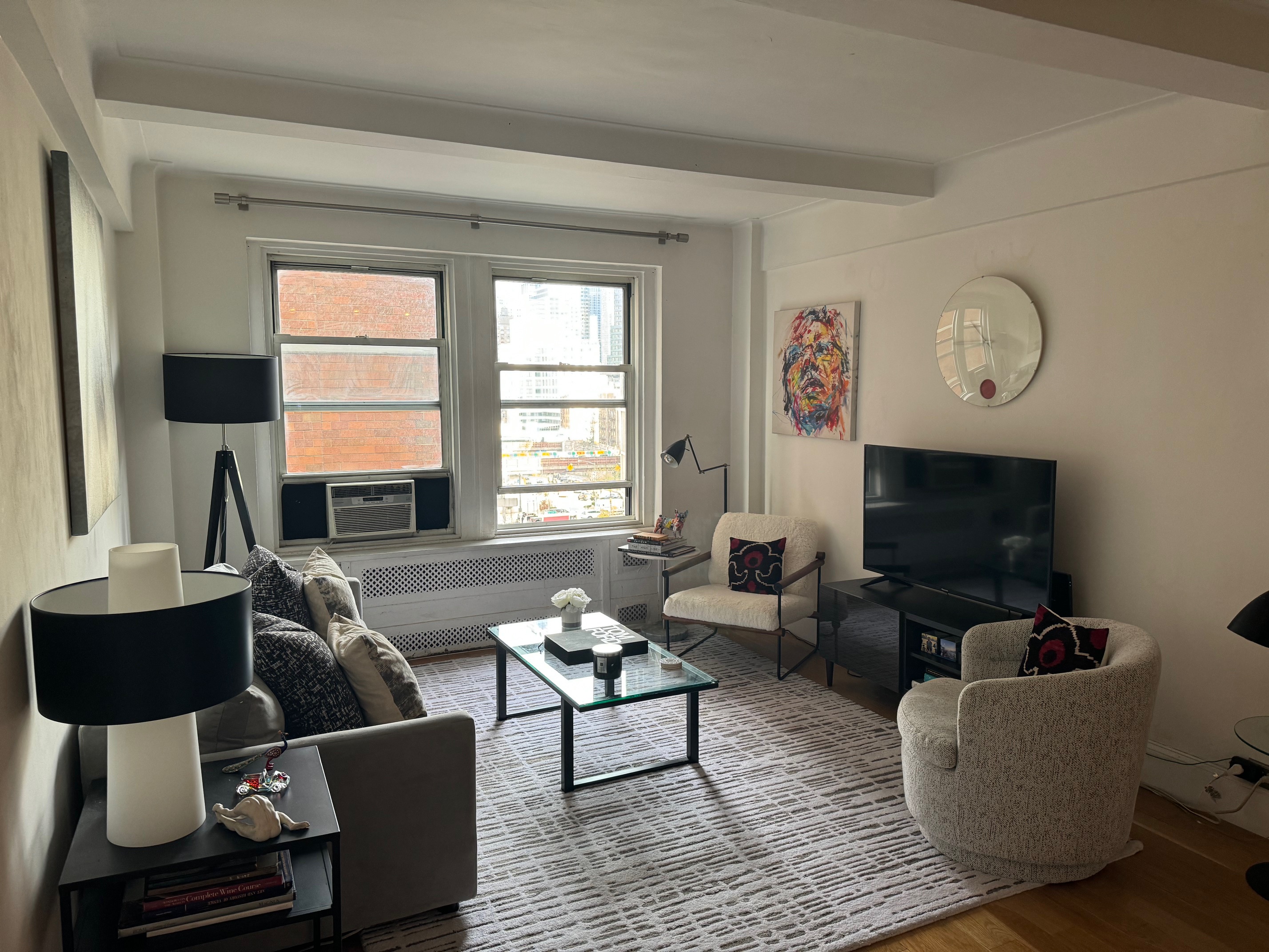 433 West 34th Street, Unit 6K Manhattan, NY 10001 - Photo 2 of 12 a living room with furniture a flat screen tv and a window