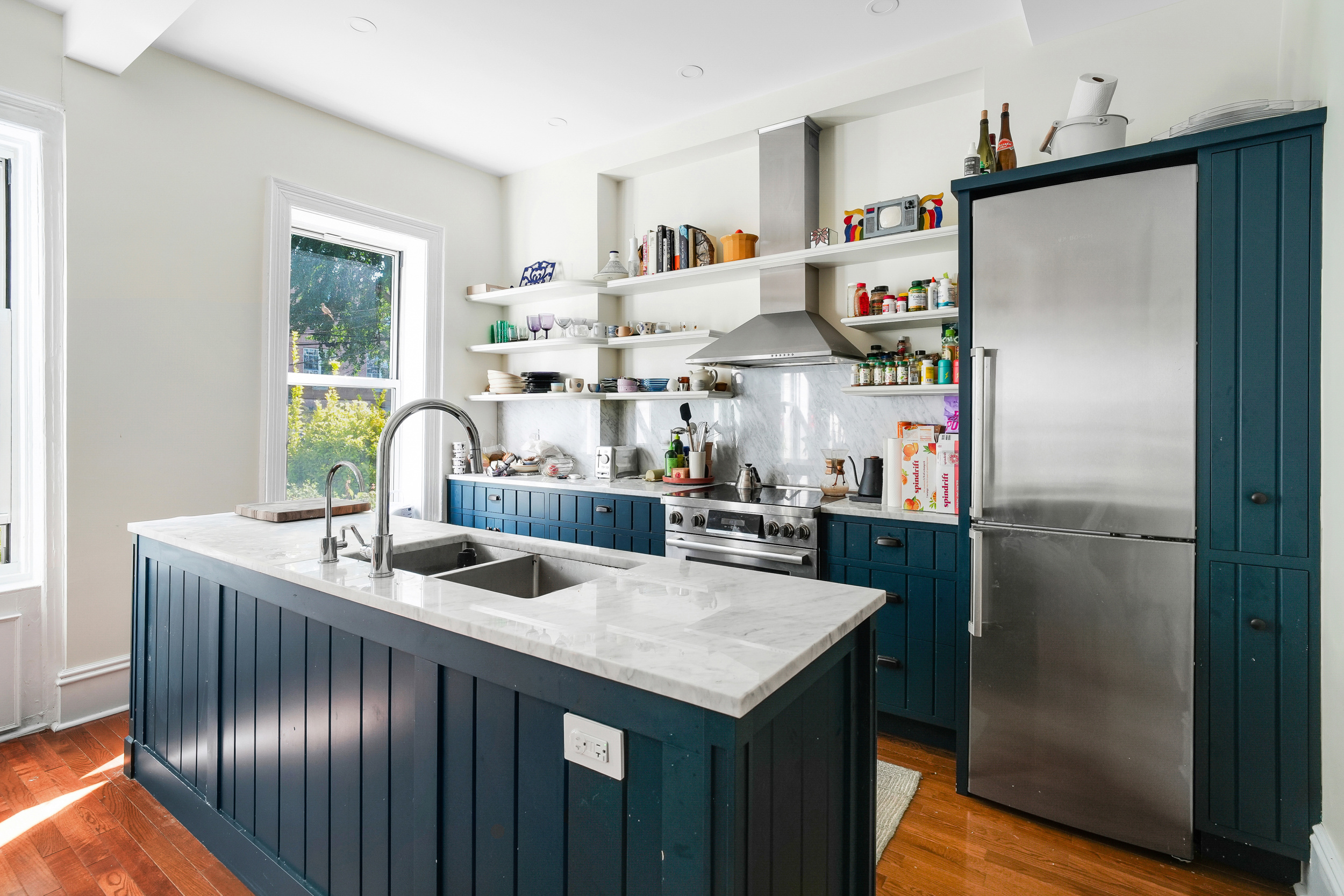 252 Jackson Street Brooklyn, NY 11211 - Photo 6 of 16 a kitchen with stainless steel appliances granite countertop a refrigerator a sink a stove and a dining table with wooden floor