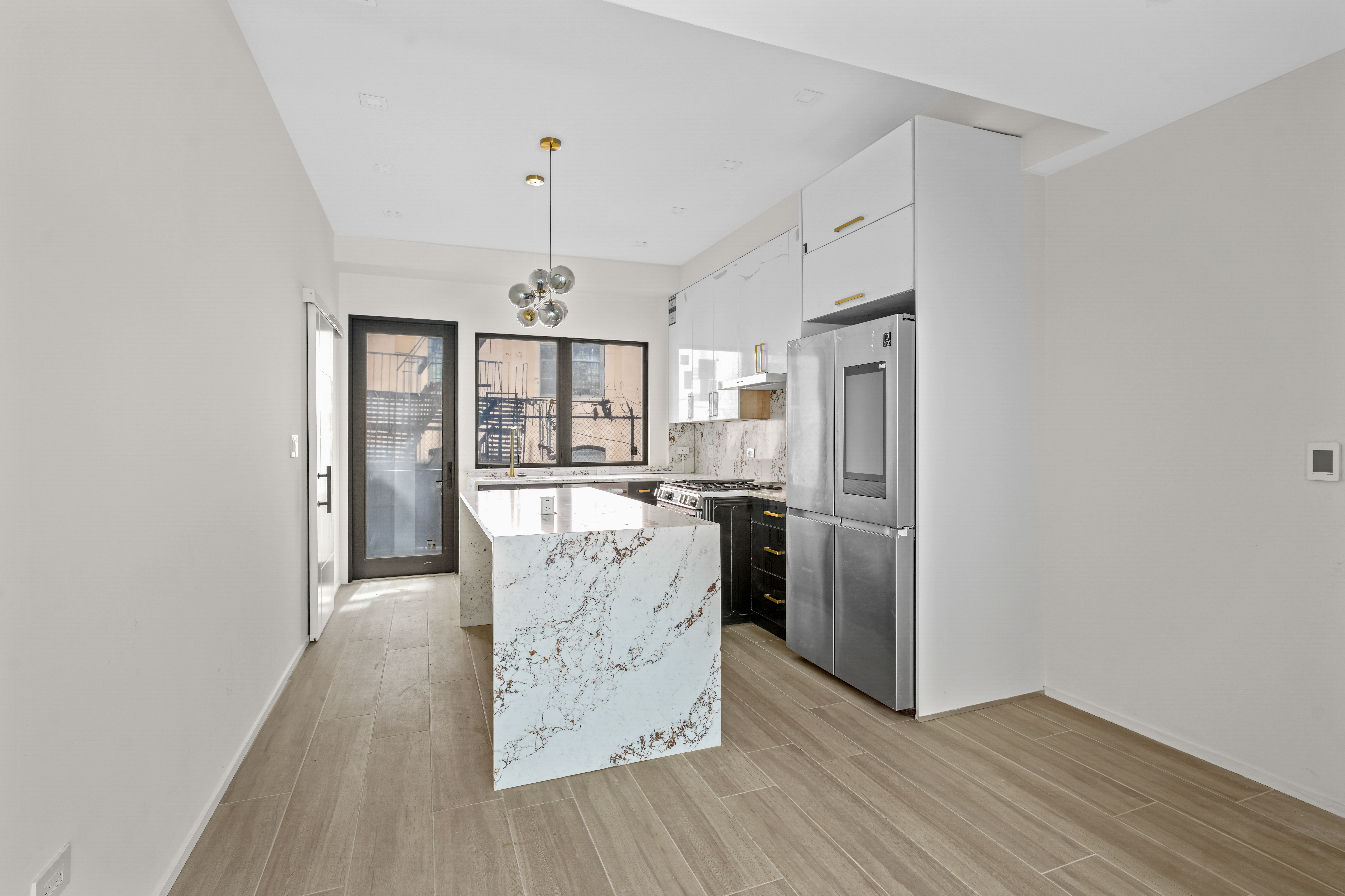 953 St Nicholas Avenue, Unit 1 Manhattan, NY 10032 - Photo 2 of 15 a kitchen with stainless steel appliances granite countertop a refrigerator and a stove top oven