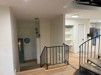 a view of staircase with lots of frames on wall and a window