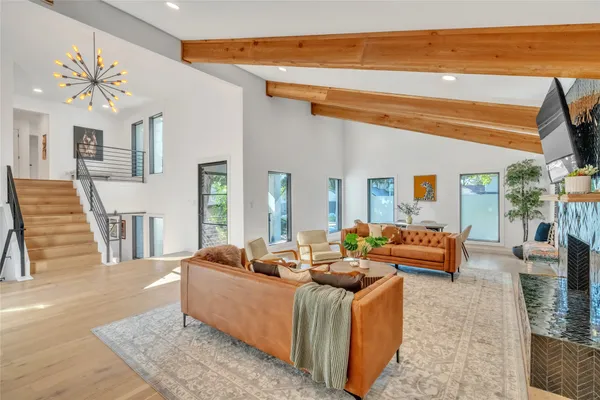 a living room with furniture a couch and large windows