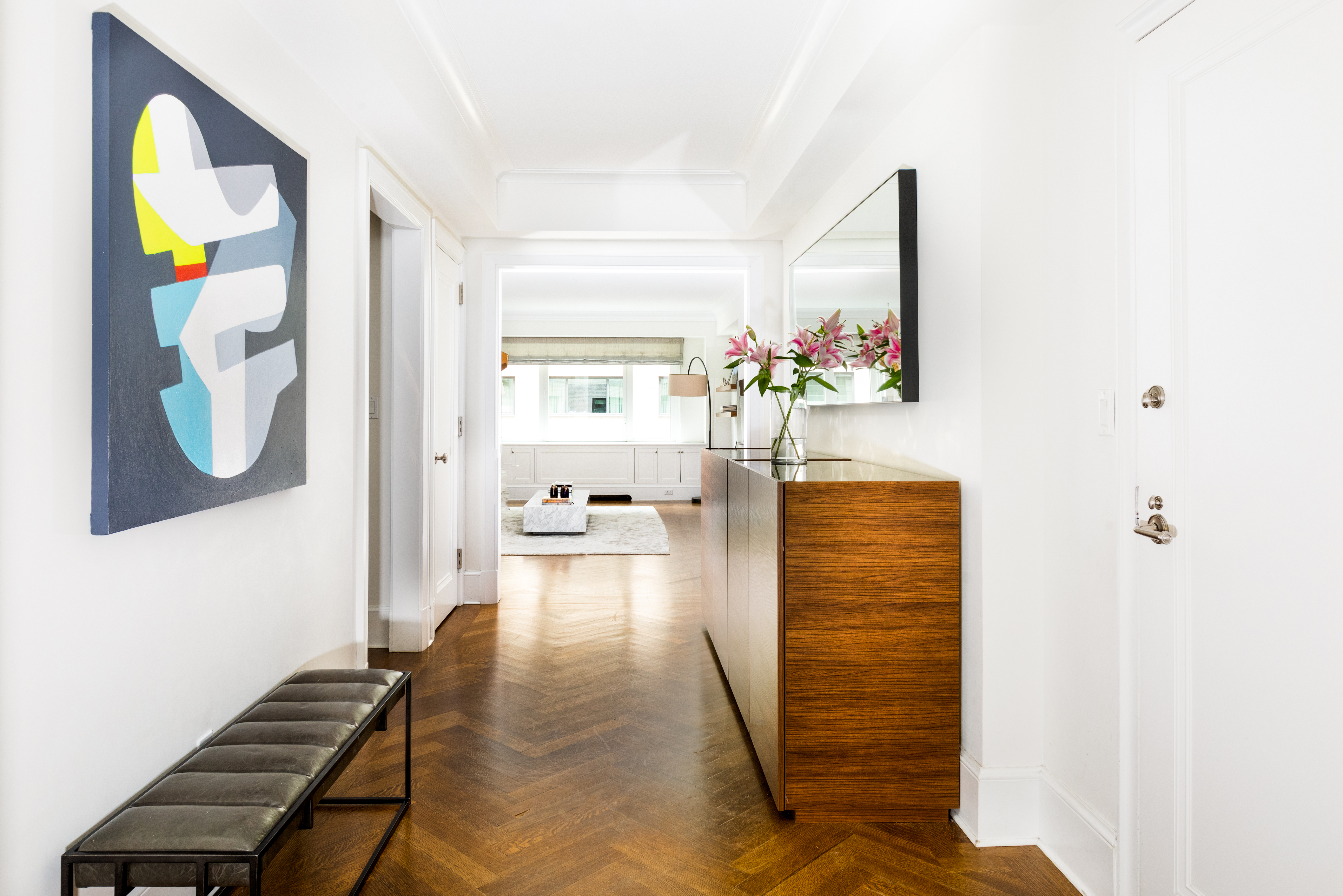 530 Park Avenue, Unit 7G Manhattan, NY 10065 - Photo 5 of 16 a hallway with painting on the wall and a potted plant
