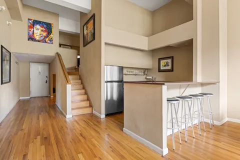 a view of entryway and hall with wooden floor