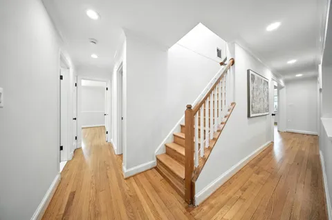 a view of a hallway with wooden floor and staircase