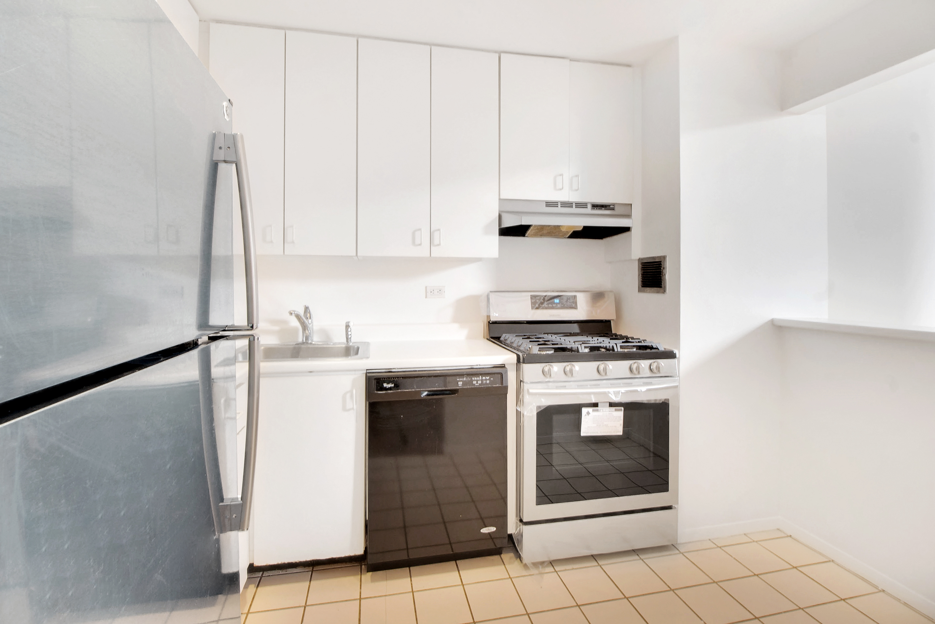 1255 5th Avenue, Unit 5J Manhattan, NY 10029 - Photo 9 of 17 a kitchen with appliances cabinets and a sink