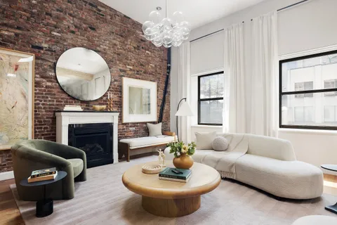 a living room with furniture a fireplace and a large window