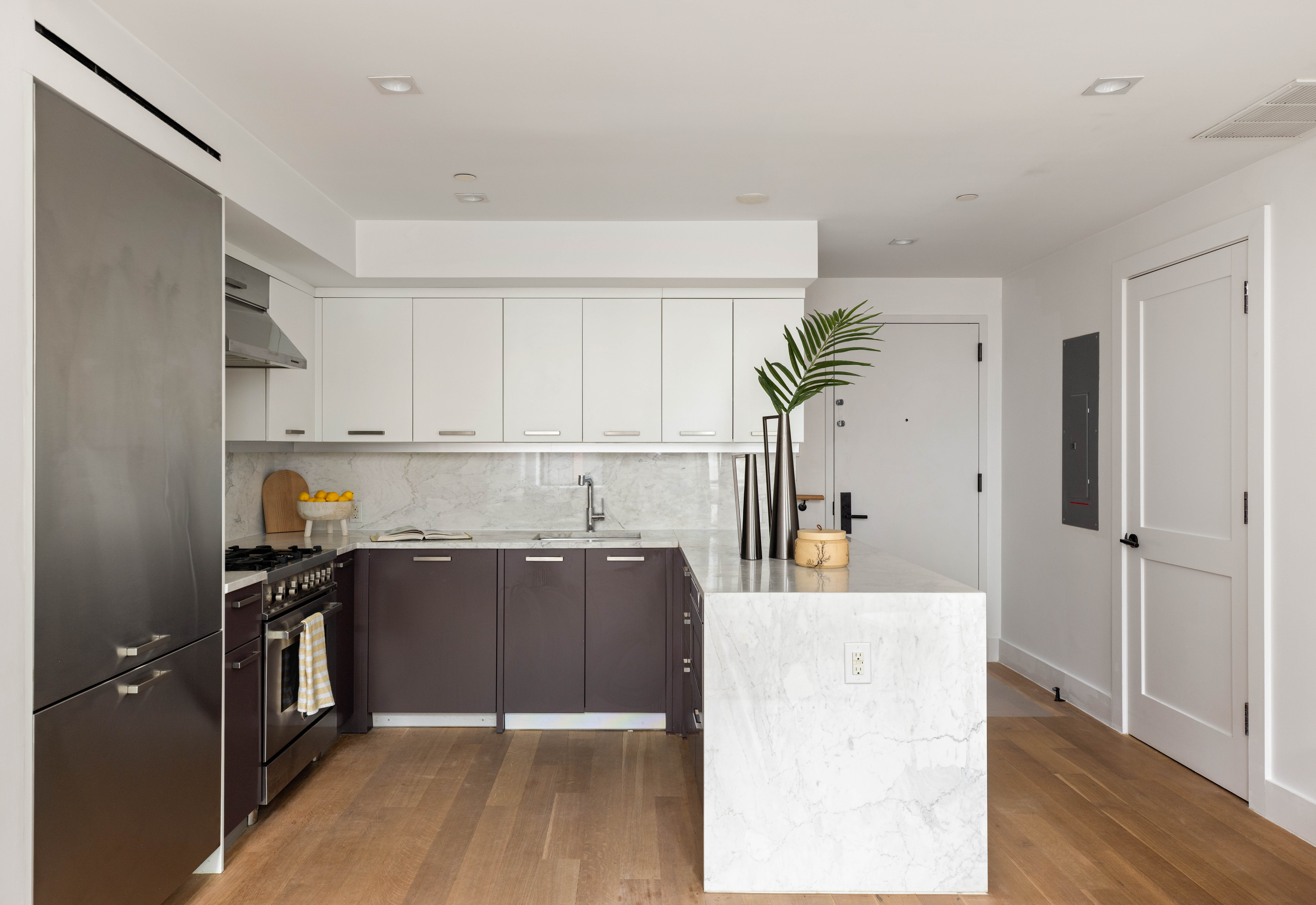 172 North 10th Street, Unit 3D Brooklyn, NY 11211 - Photo 4 of 16 a kitchen with kitchen island a counter top space a sink wooden floor and stainless steel appliances