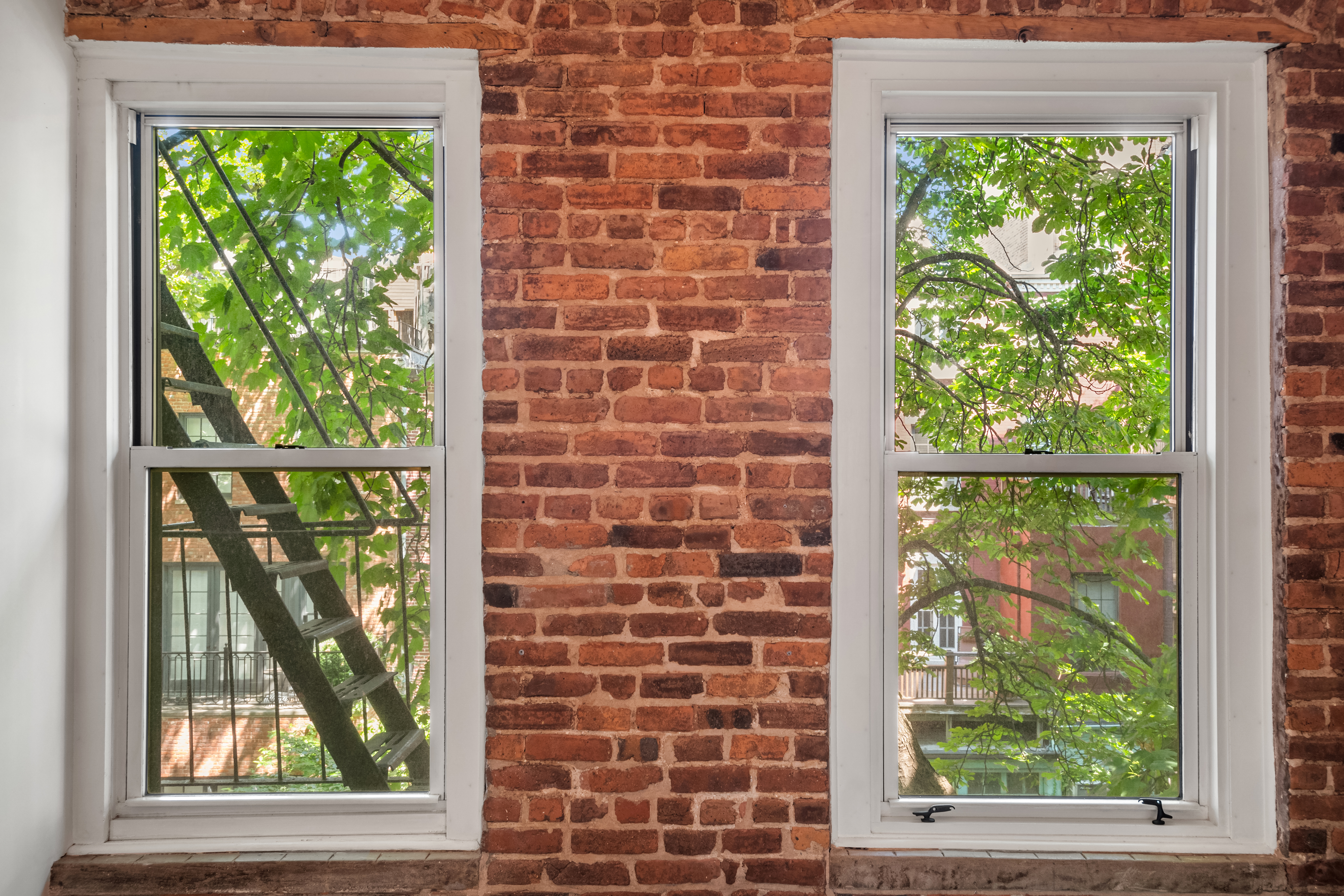 77 Perry Street, Unit 3D Manhattan, NY 10014 - Photo 6 of 11 a brick wall with a view of a city from a window
