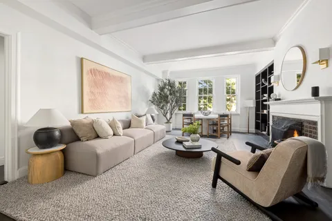 a living room with furniture a fireplace and a large window