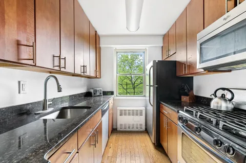 a kitchen with granite countertop a sink stainless steel appliances and cabinets