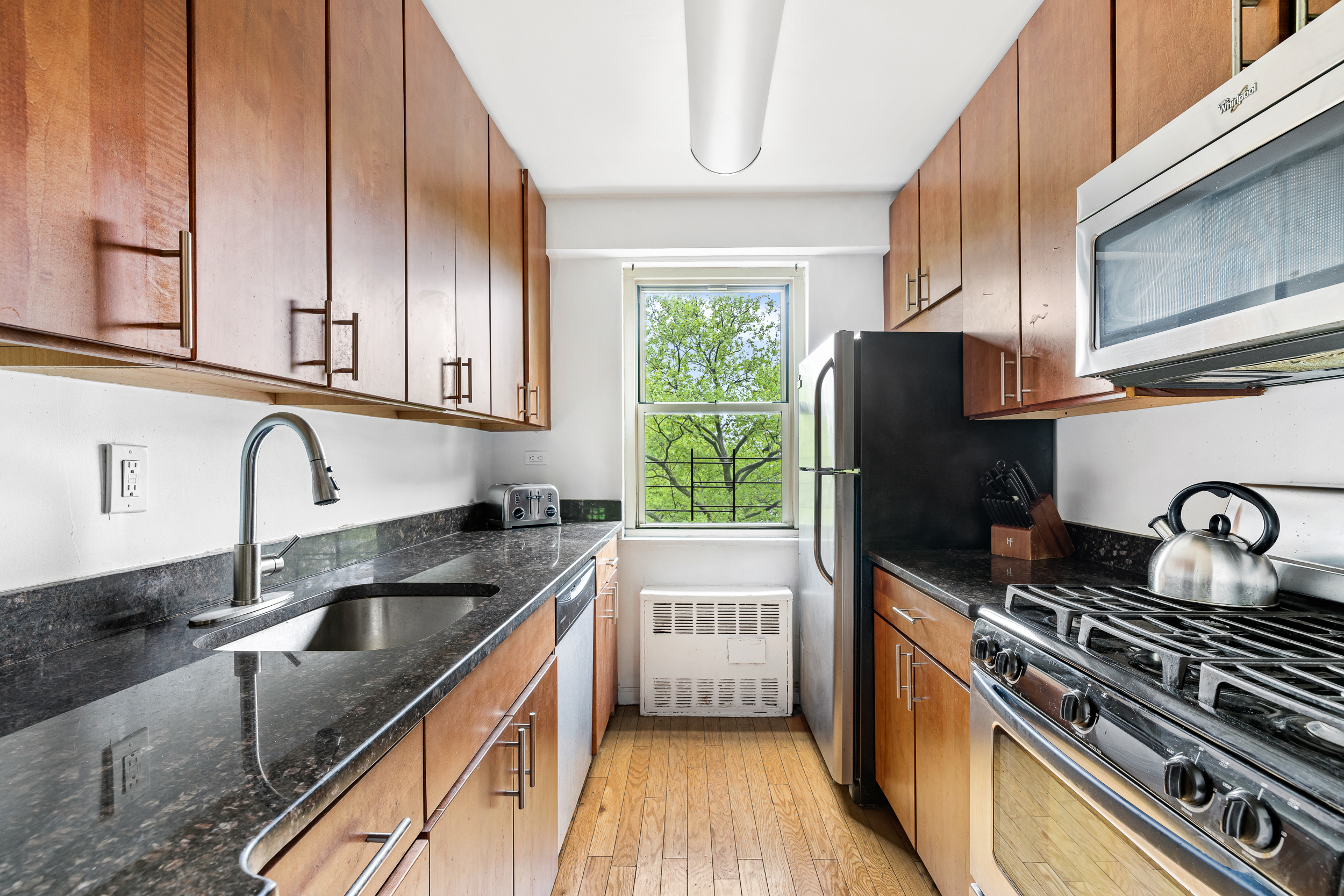 1065 Vermont Street, Unit 4L Brooklyn, NY 11207 - Photo 3 of 11 a kitchen with granite countertop a sink stainless steel appliances and cabinets