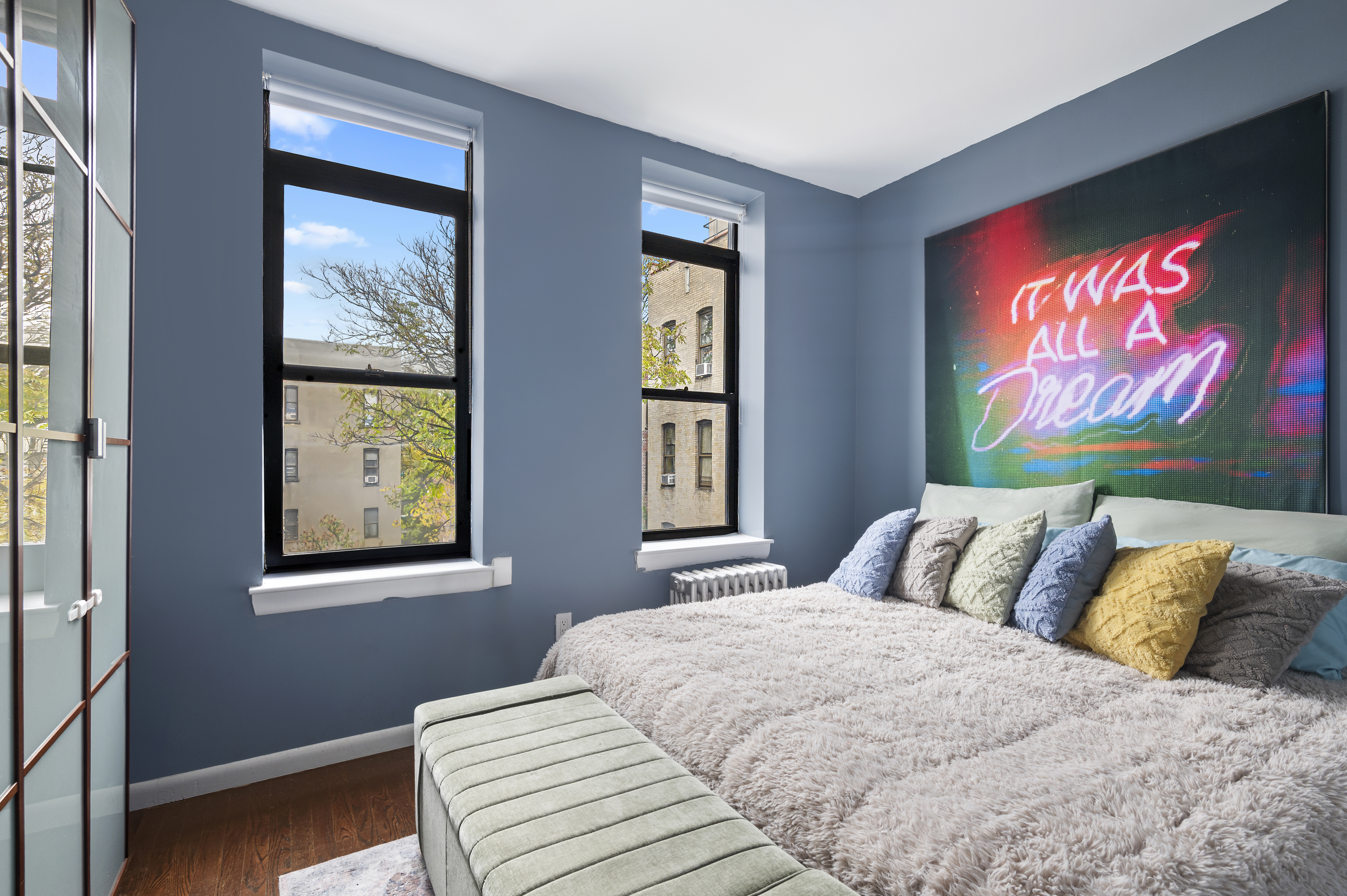 11 St Nicholas Avenue, Unit 5A/5H Manhattan, NY 10026 - Photo 4 of 6 a bedroom with a bed and wooden floor