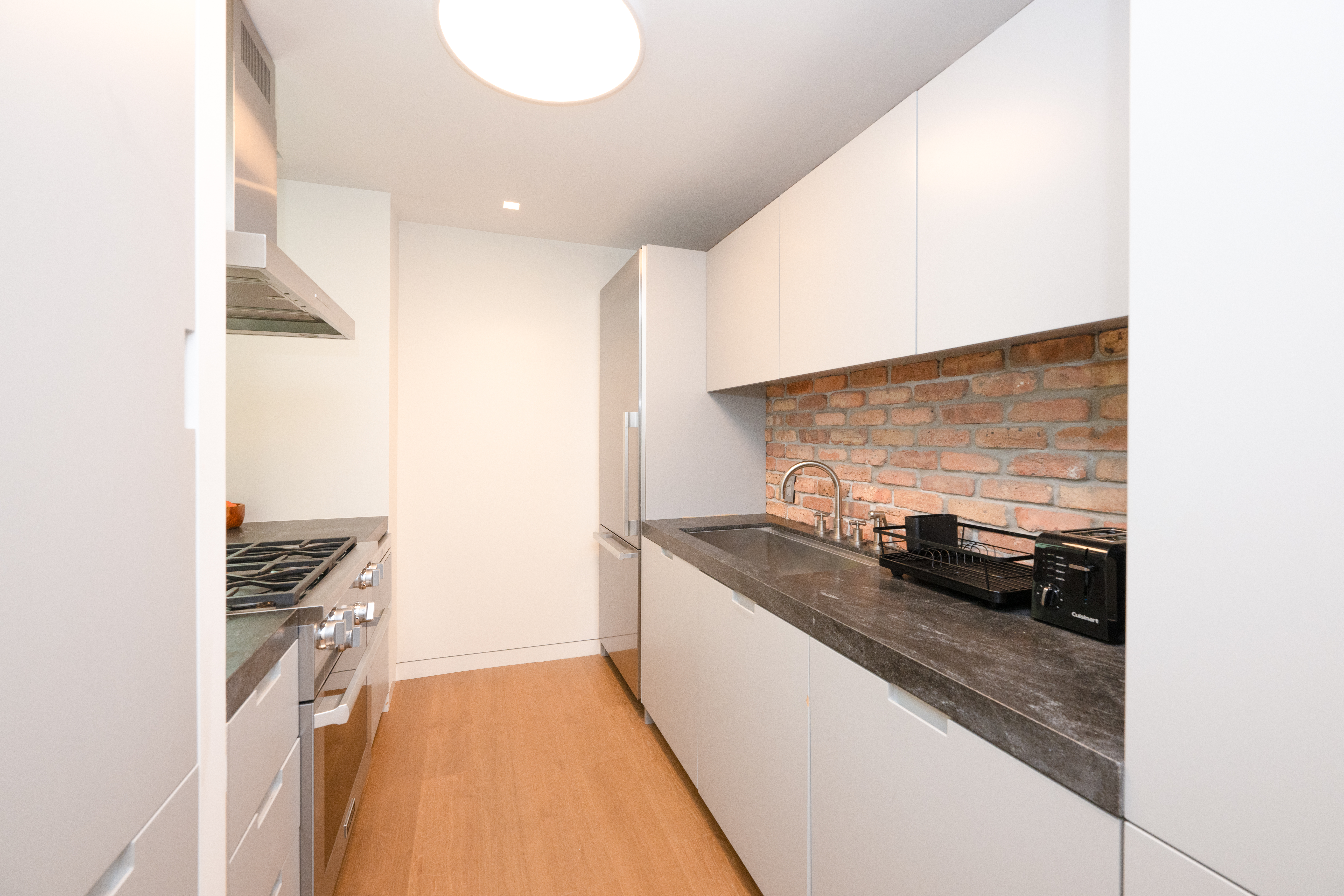 124 East 79th Street, Unit 7D Manhattan, NY 10075 - Photo 4 of 26 a kitchen with granite countertop a sink and a stove