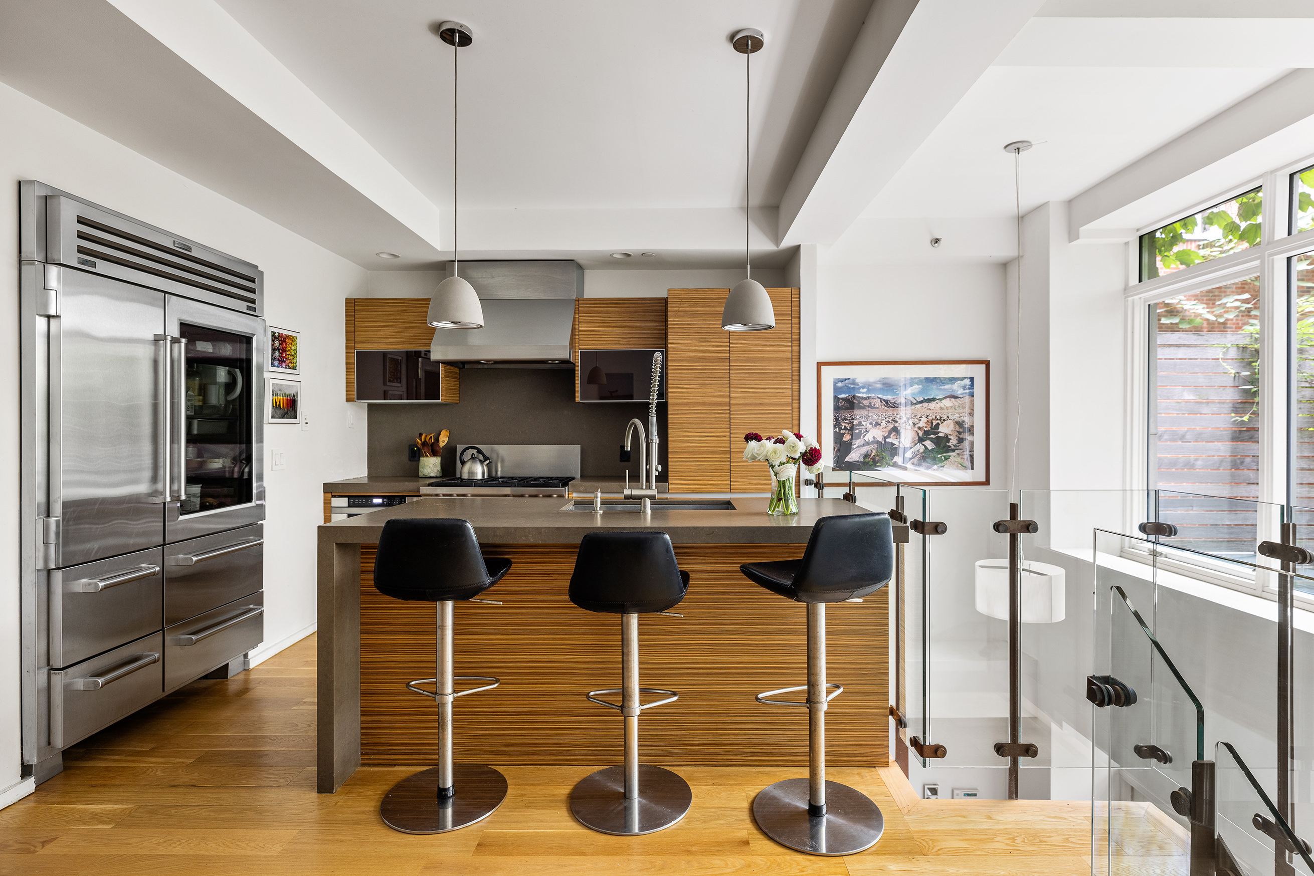 271 West 122nd Street, Unit A Manhattan, NY 10027 - Photo 5 of 19 a kitchen with stainless steel appliances kitchen island granite countertop a table and chairs in it
