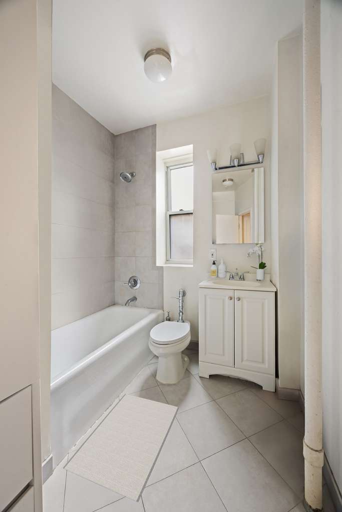223 East 50th Street, Unit 6B Manhattan, NY 10022 - Photo 5 of 7 a bathroom with a sink a toilet and a bathtub