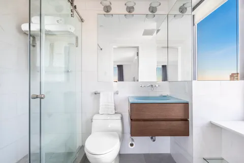 a bathroom with a sink a toilet and shower
