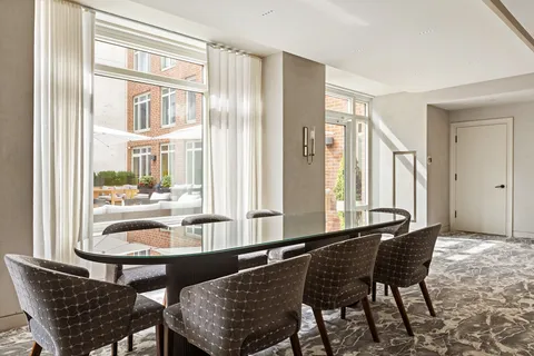 a dining room with furniture and large windows