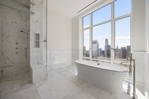 a bathroom with a double vanity sink a mirror and a bathtub