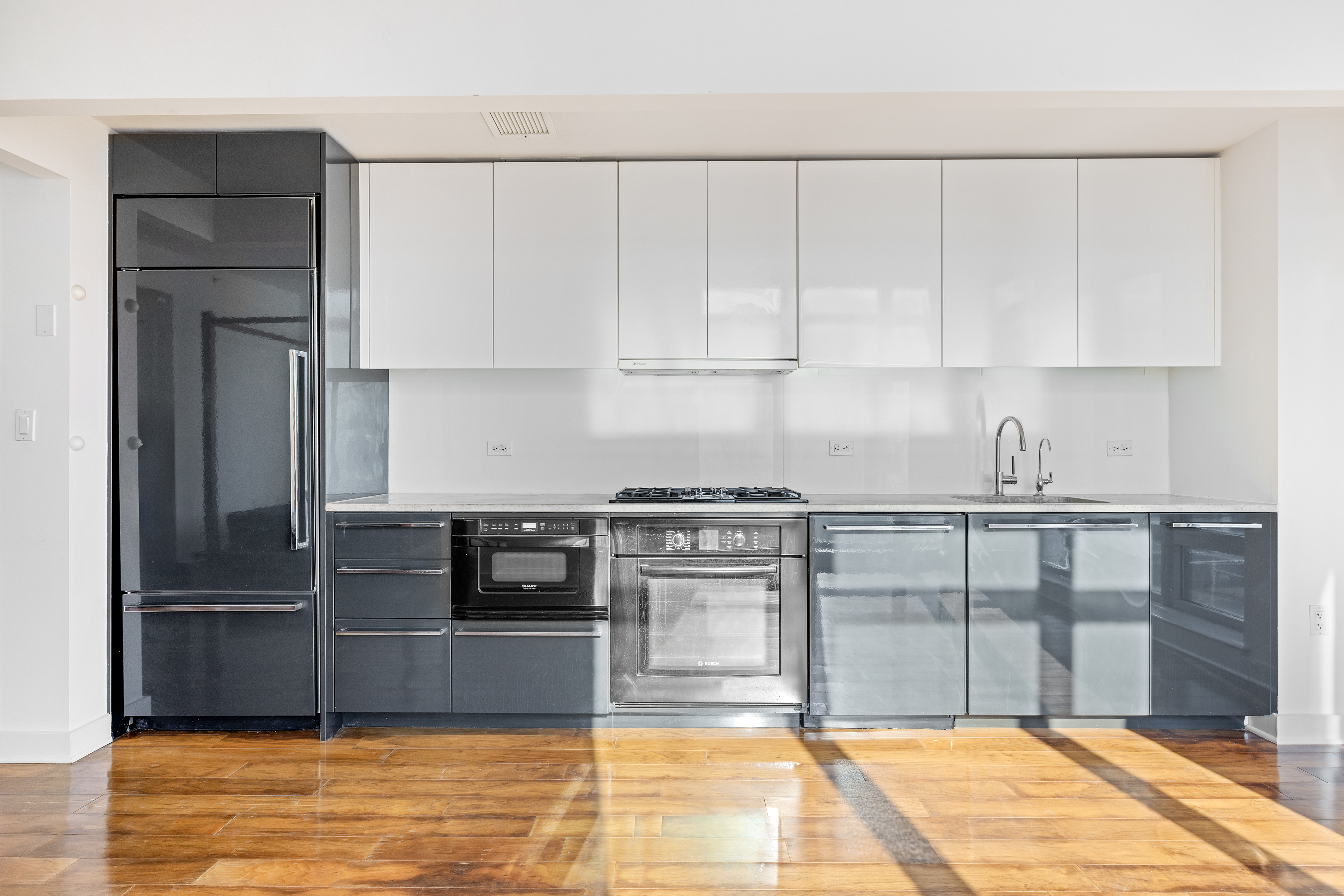 2 Northside Piers, Unit 5Q Brooklyn, NY 11249 - Photo 2 of 11 a kitchen with granite countertop a refrigerator and a stove top oven
