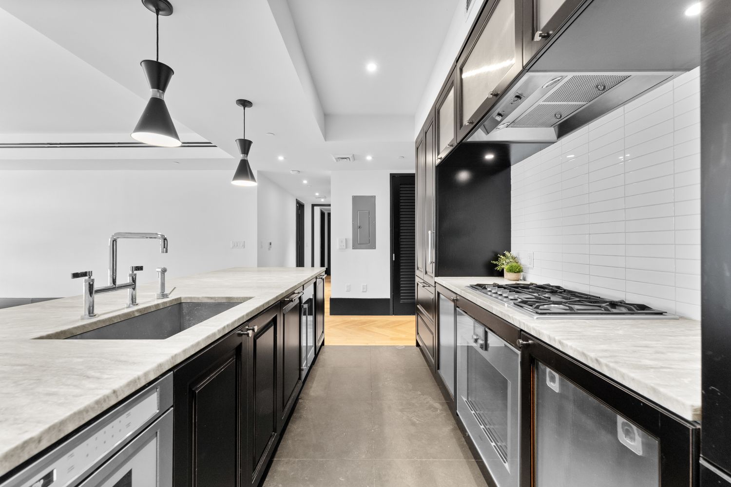 a kitchen with stainless steel appliances granite countertop a sink a stove and a wooden floors