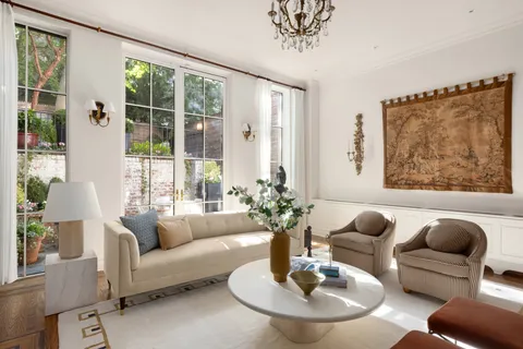 a living room with furniture potted plant and a large window