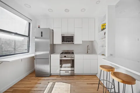 a kitchen with stainless steel appliances granite countertop a refrigerator and a stove top oven