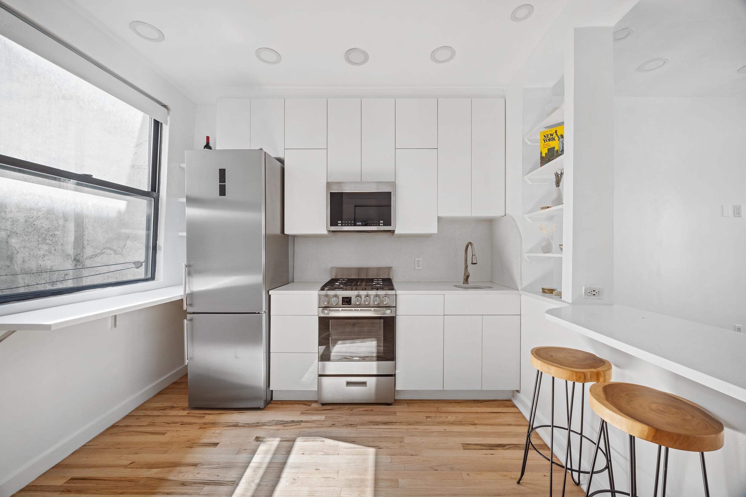 13 Downing Street, Unit 9 Manhattan, NY 10014 - Photo 4 of 8 a kitchen with stainless steel appliances granite countertop a refrigerator and a stove top oven