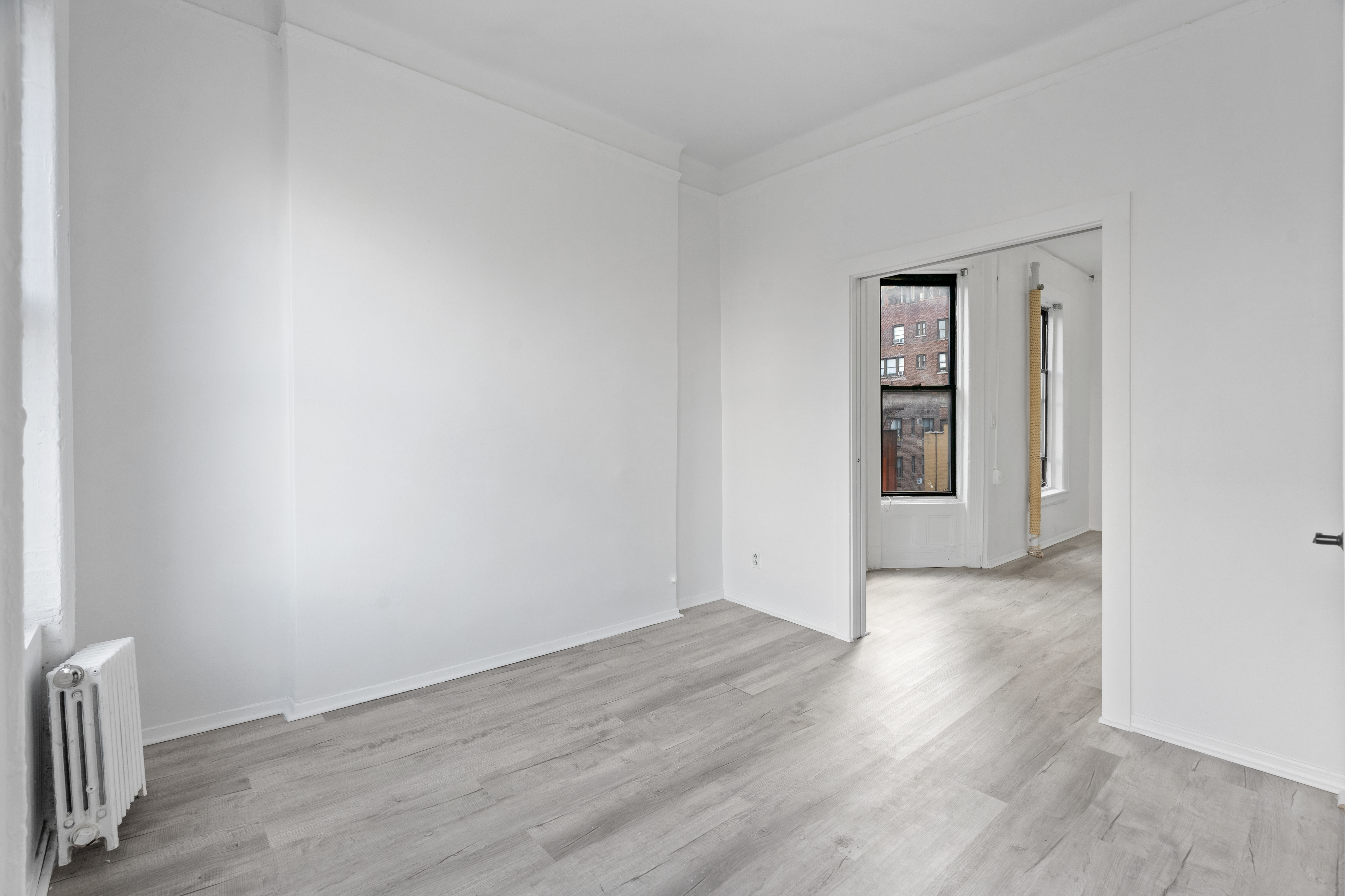 826 9th Avenue, Unit 5RS Manhattan, NY 10019 - Photo 8 of 15 an empty room with wooden floor and windows