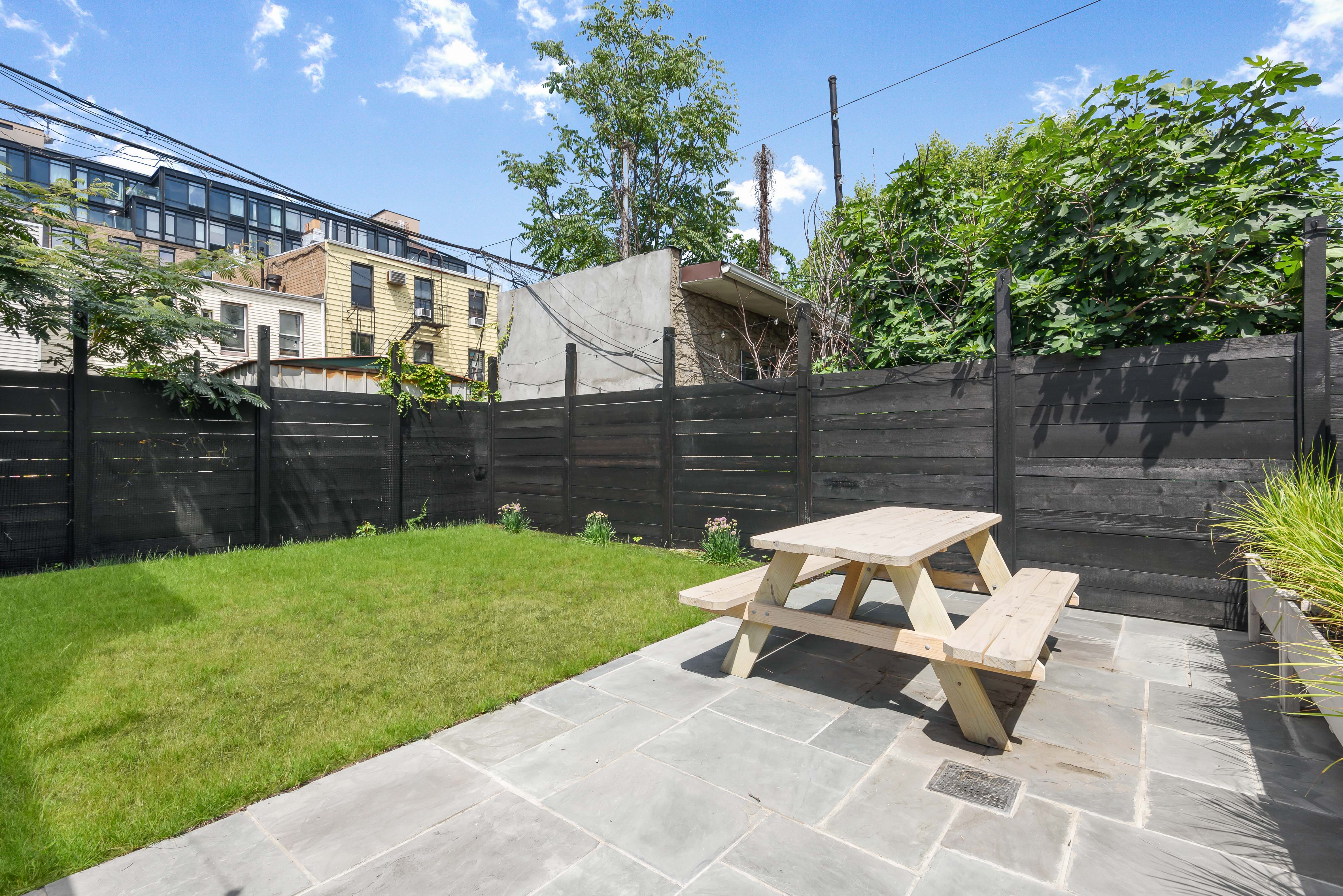 179 Devoe Street, Unit 2 Brooklyn, NY 11211 - Photo 4 of 19 a wooden bench sitting in the backyard of a house