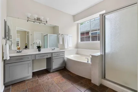a bathroom with a tub sink shower and mirror