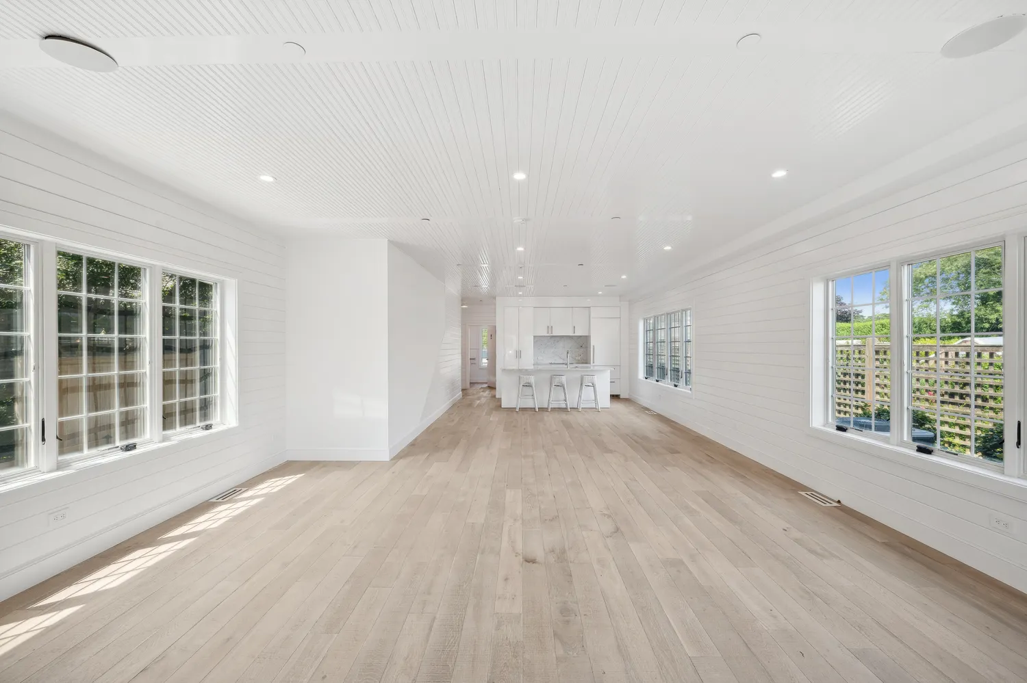 a kitchen with white cabinets and chairs