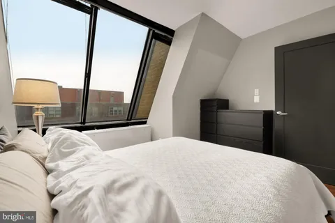 a bedroom with a large bed and a mirror