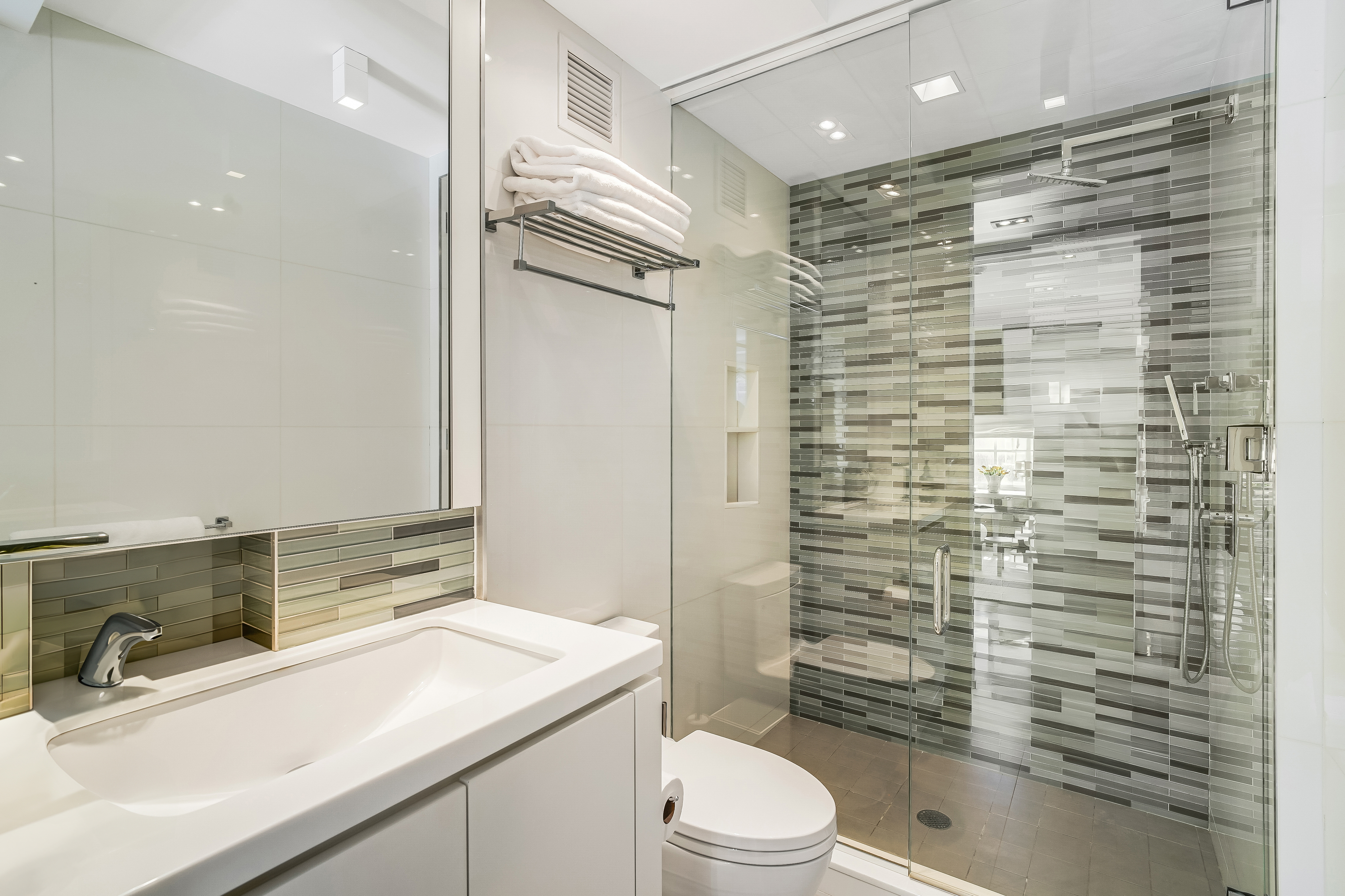 1 5th Avenue, Unit 5GH Manhattan, NY 10003 - Photo 21 of 26 a bathroom with a sink a toilet a mirror and shower