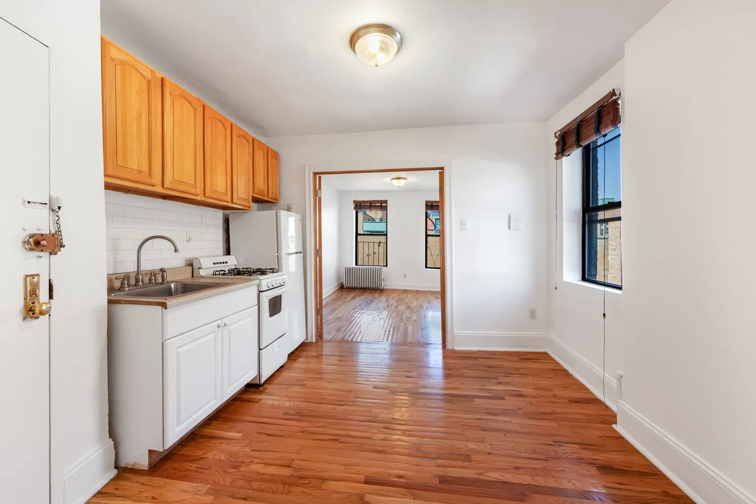 a large kitchen with a wooden floor and cabinets