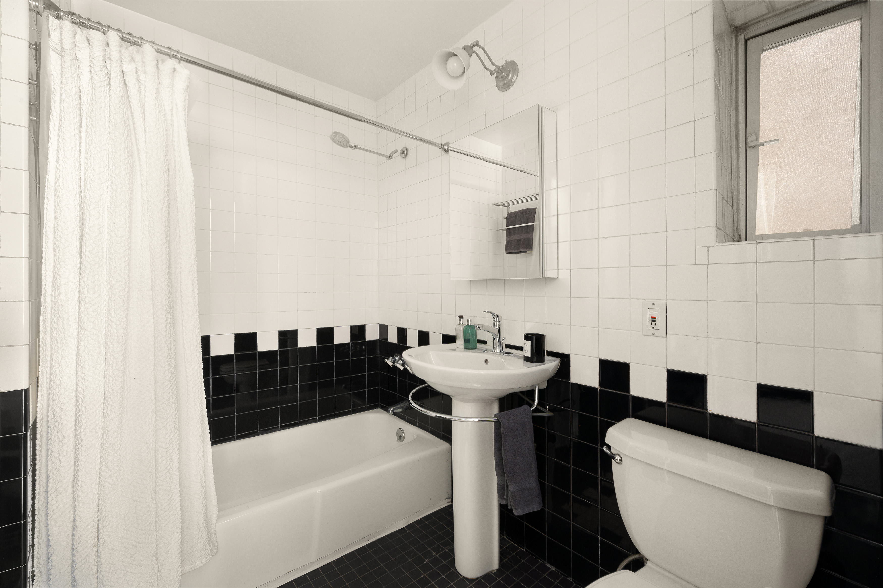 77 Perry Street, Unit 1A Manhattan, NY 10014 - Photo 5 of 6 a bathroom with a sink a toilet a bathtub and shower