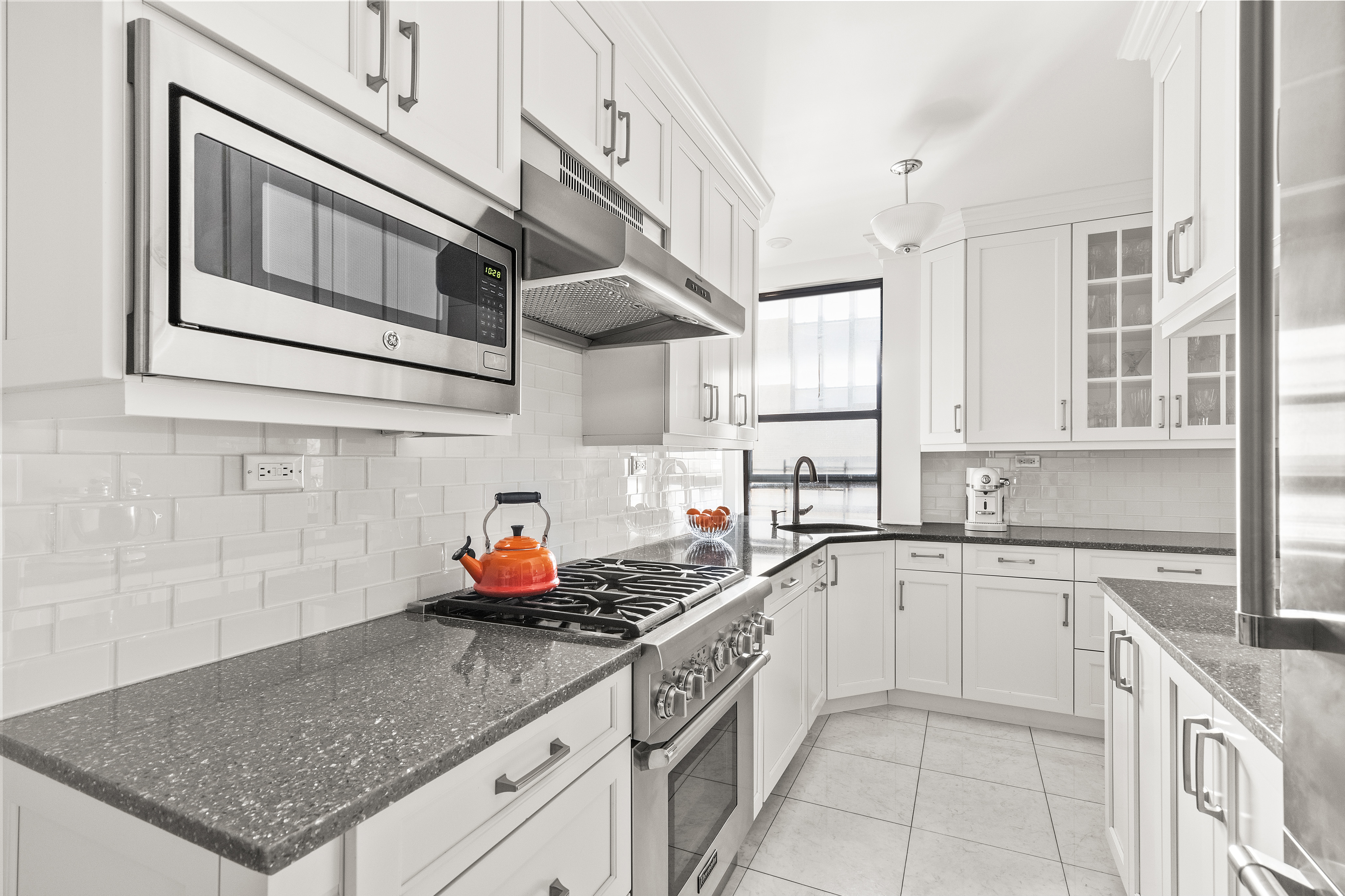 410 East 57th Street, Unit 15BE Manhattan, NY 10022 - Photo 5 of 18 a kitchen with stainless steel appliances granite countertop a sink stove and cabinets